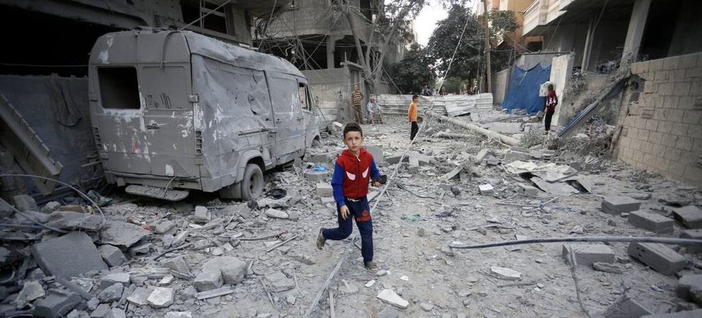 A boy runs through the destroyed streets of Gaza