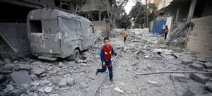 A boy runs through the destroyed streets of Gaza
