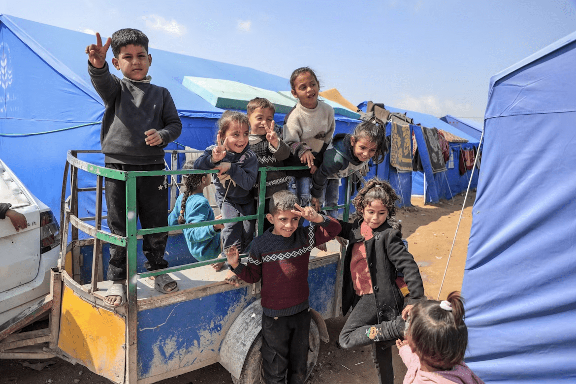 Gaza - Palestine Children smile despite the suffering they experience every minute from the heat, lack of water, tents and diseases in a camp for displaced people in the northern Gaza Strip.

